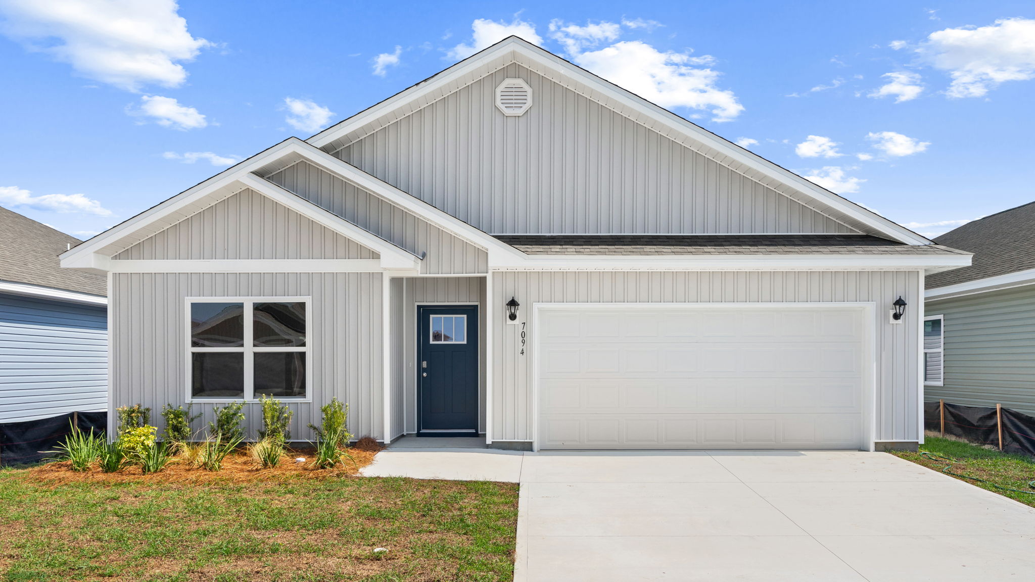 Beau plan at Liberty front of home with vinyl siding and two car garage.