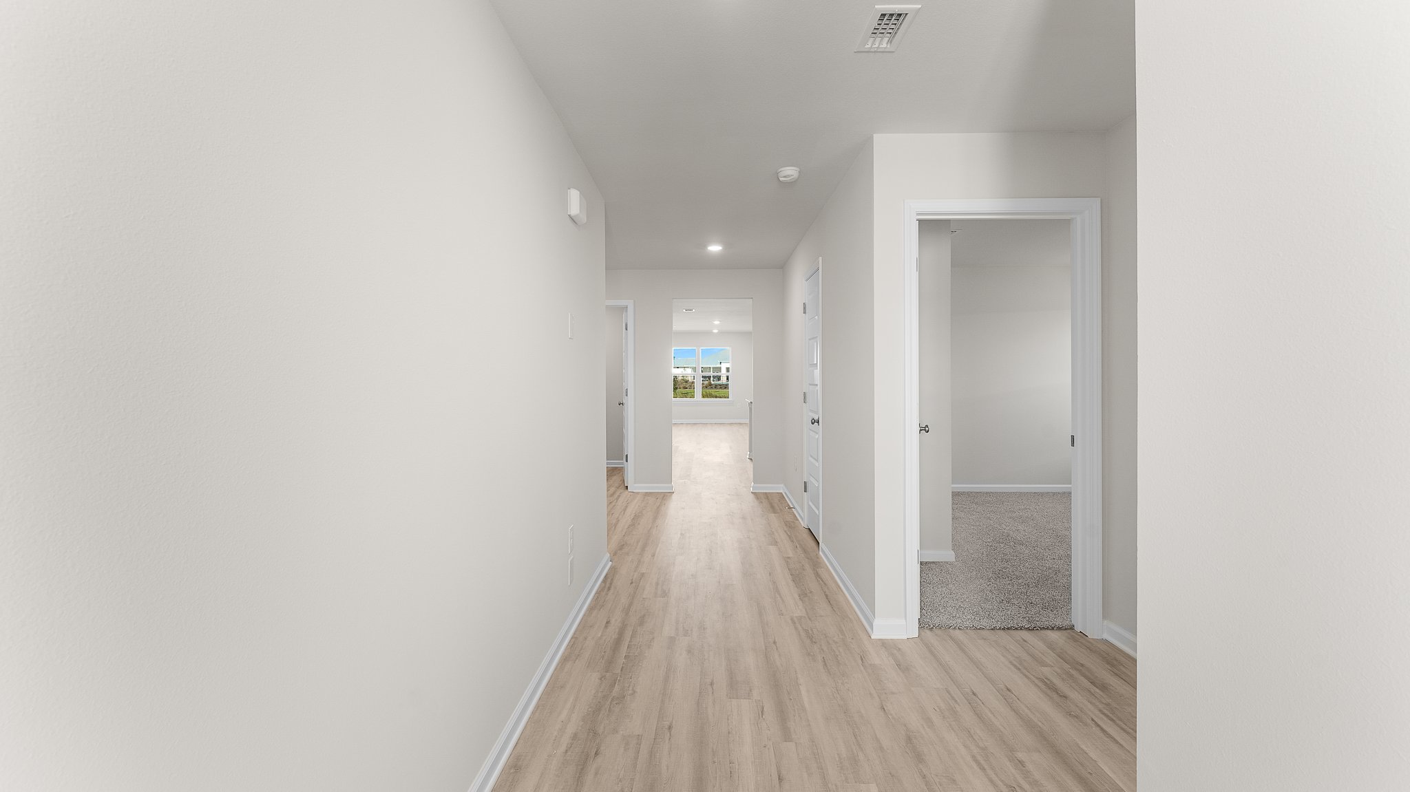 Front entrance and hallway with EVP flooring next to bathroom and bedrooms.