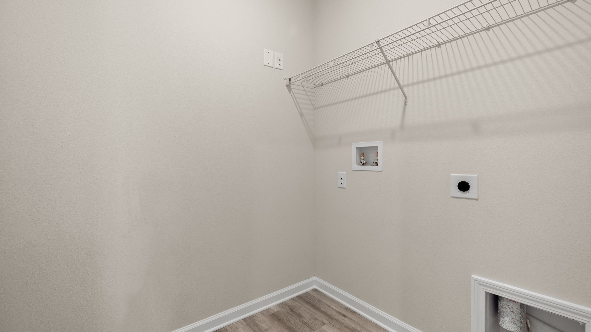 Laundry room in hallway with ventilated shelving.