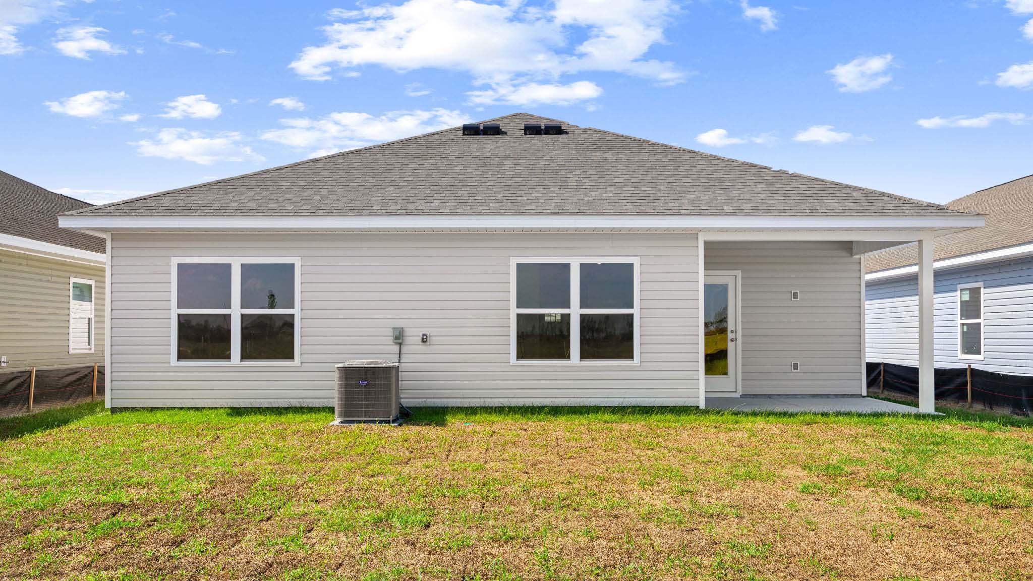 Beau plan rear of home with covered back patio.