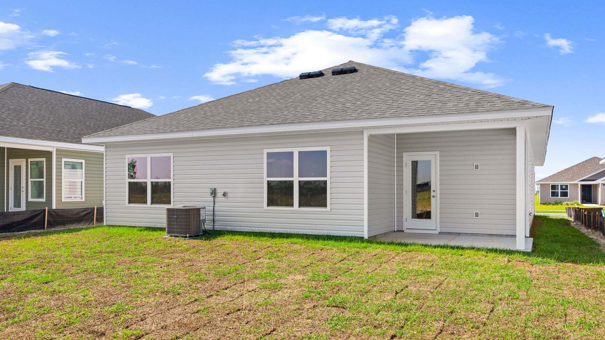 Beau plan rear of home with covered back patio.