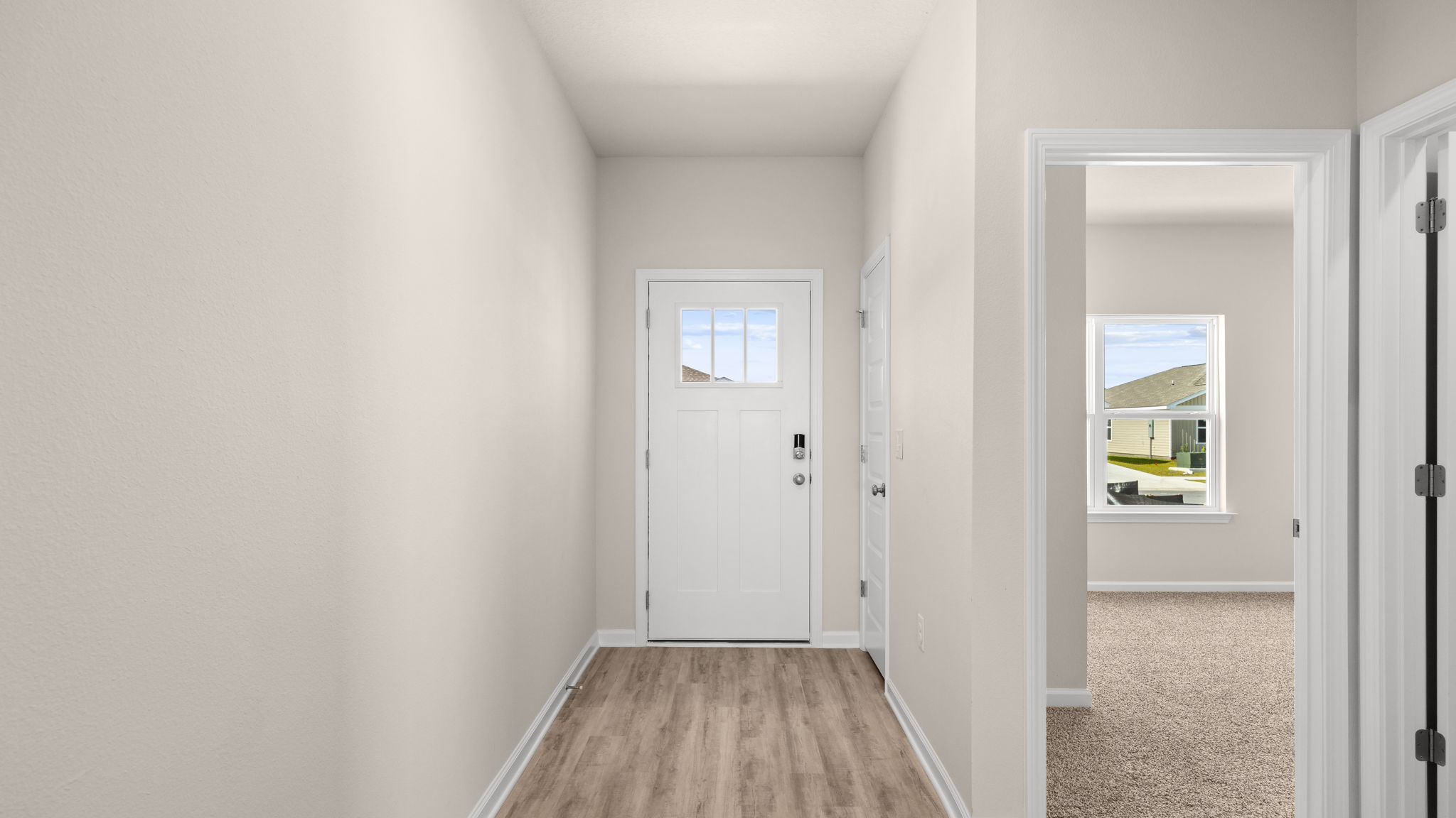 Front entrance hallway with EVP flooring next to garage and bedrooms.