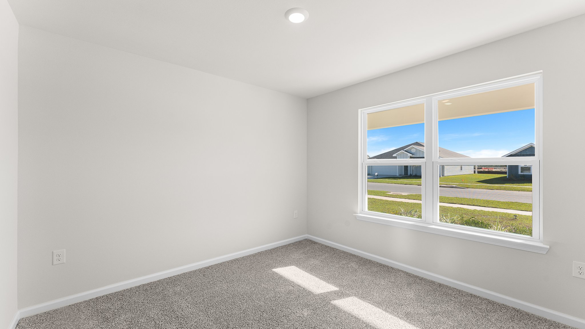 Bedroom with carpet floors and two windows.