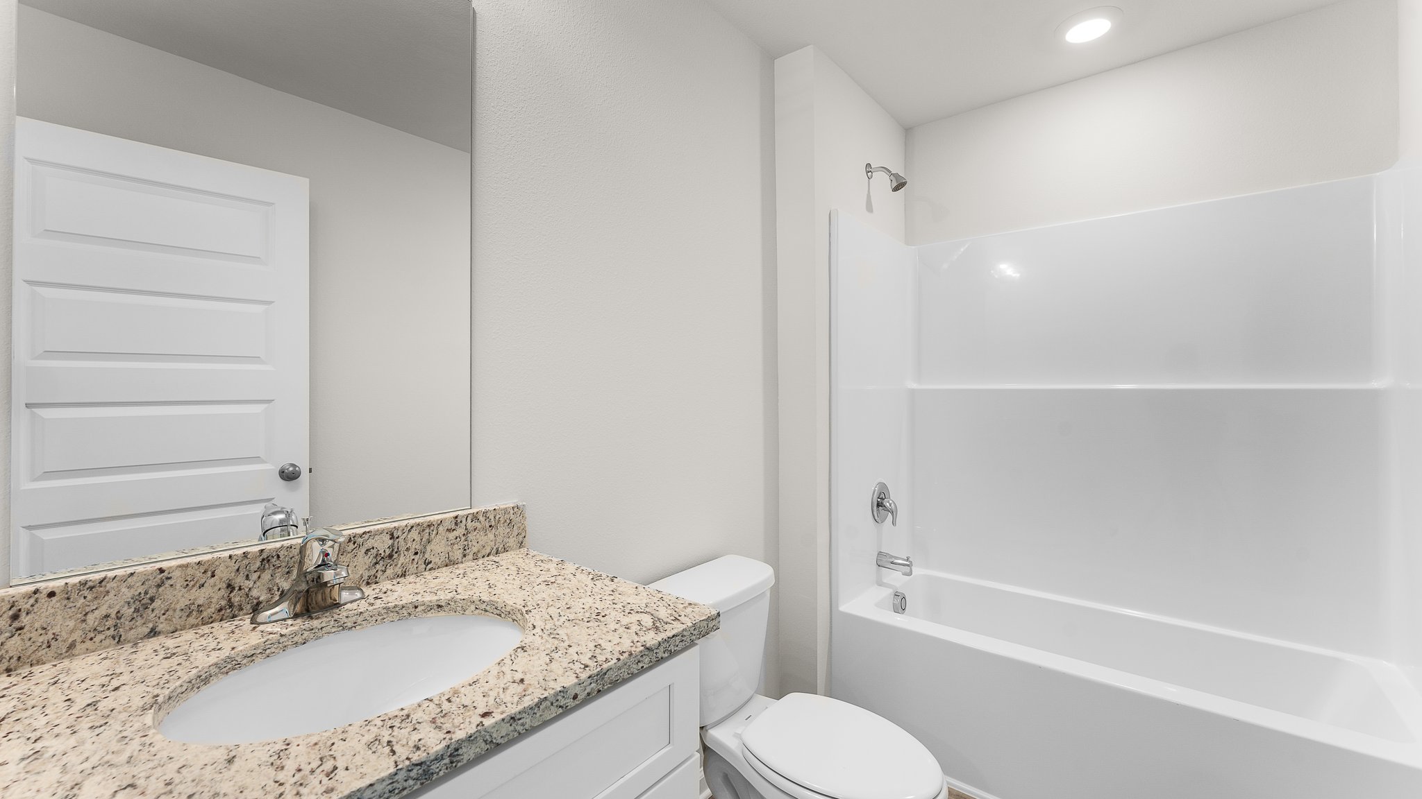 Bathroom with granite countertops and single vanity and white cabinets and shower.