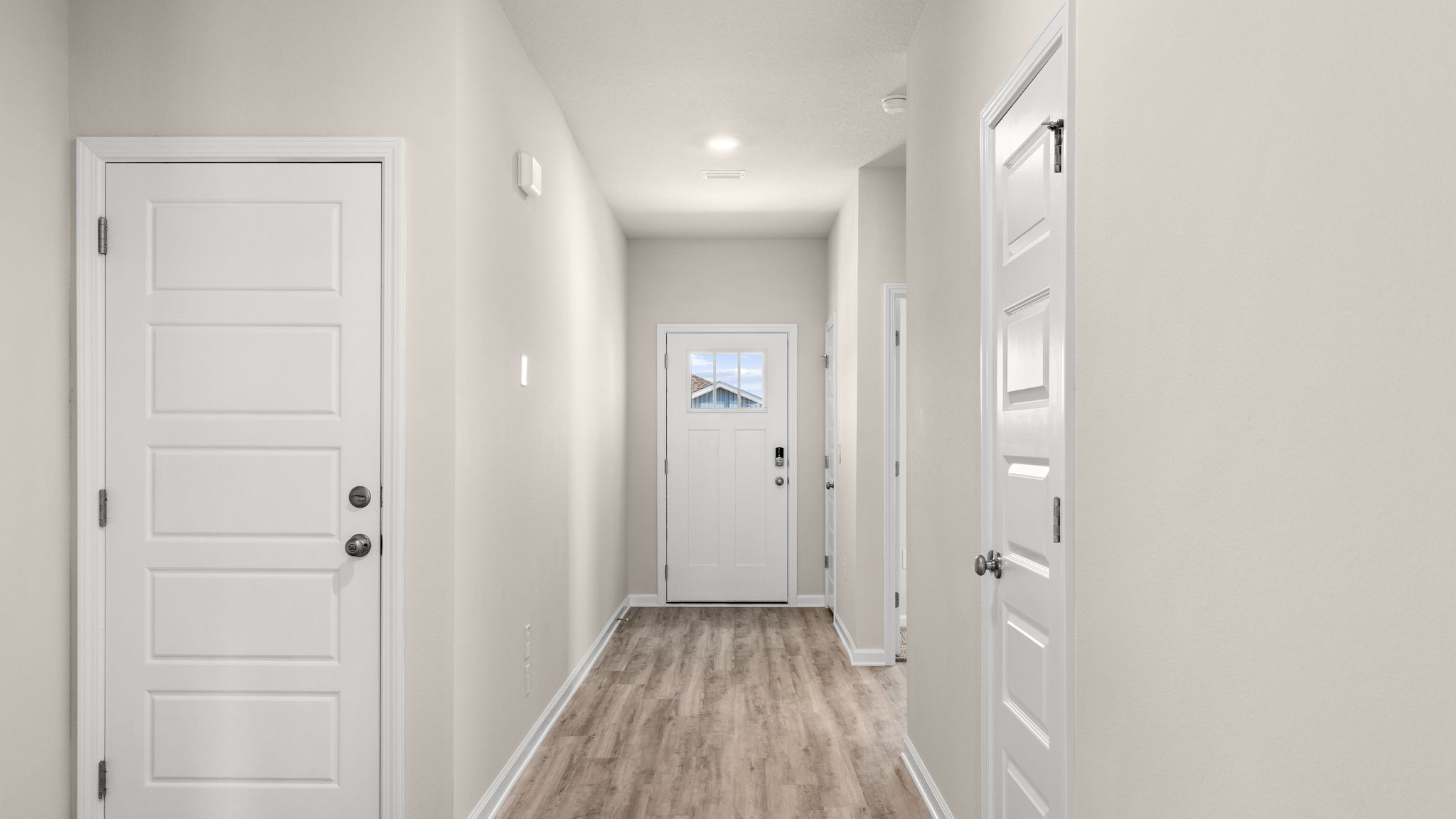 Front entrance hallway with EVP flooring next to garage and bedrooms.