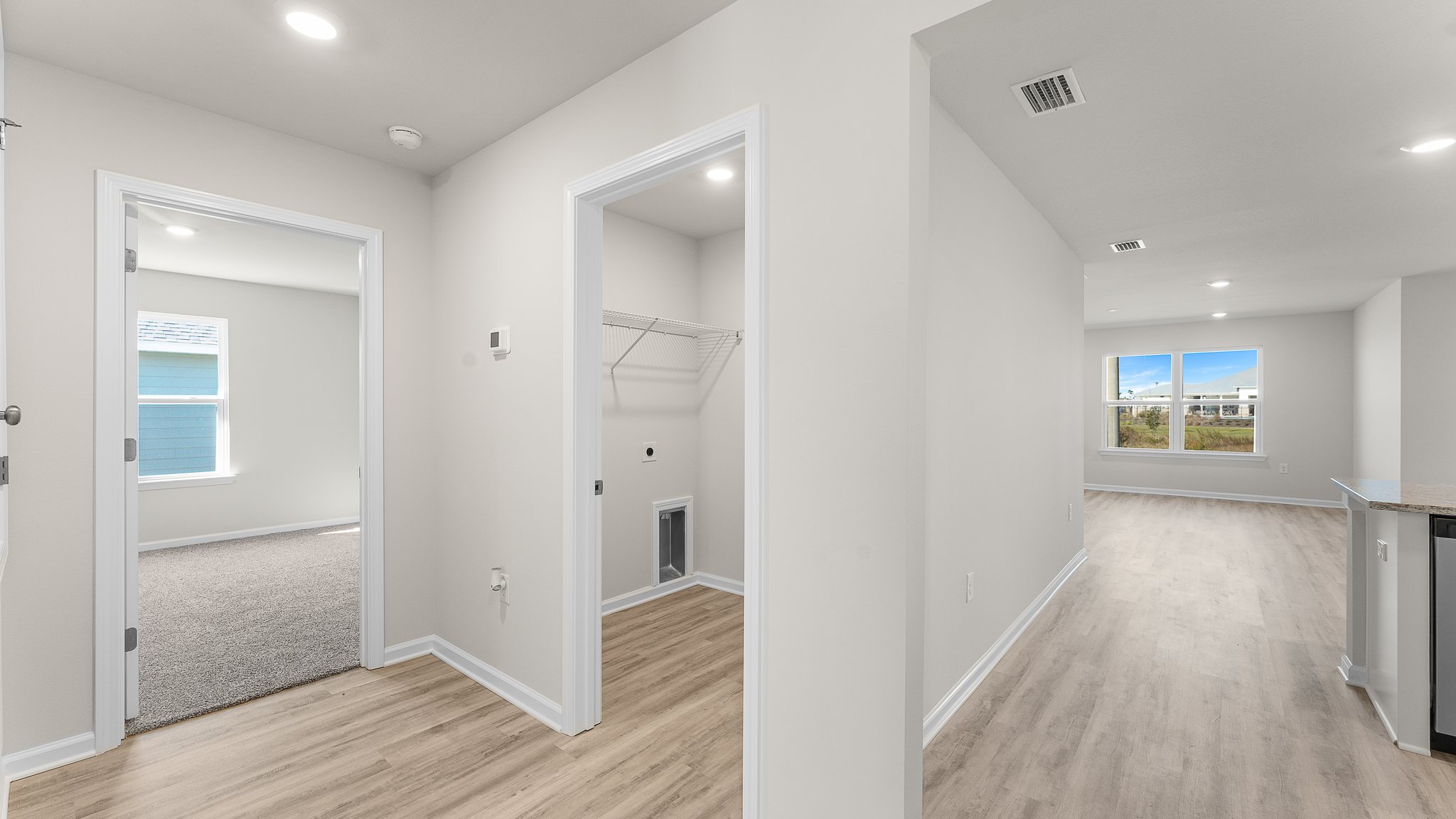 Hallway by garage entrance and bedroom and laundry room.
