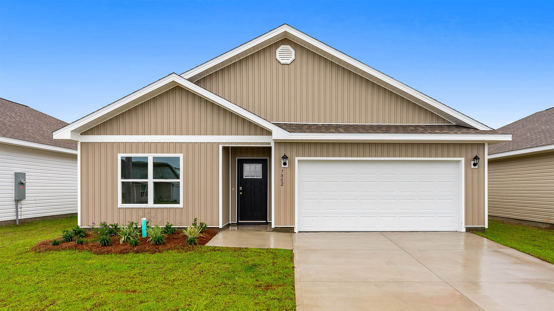 Beau plan with vinyl siding and two-car garage.
