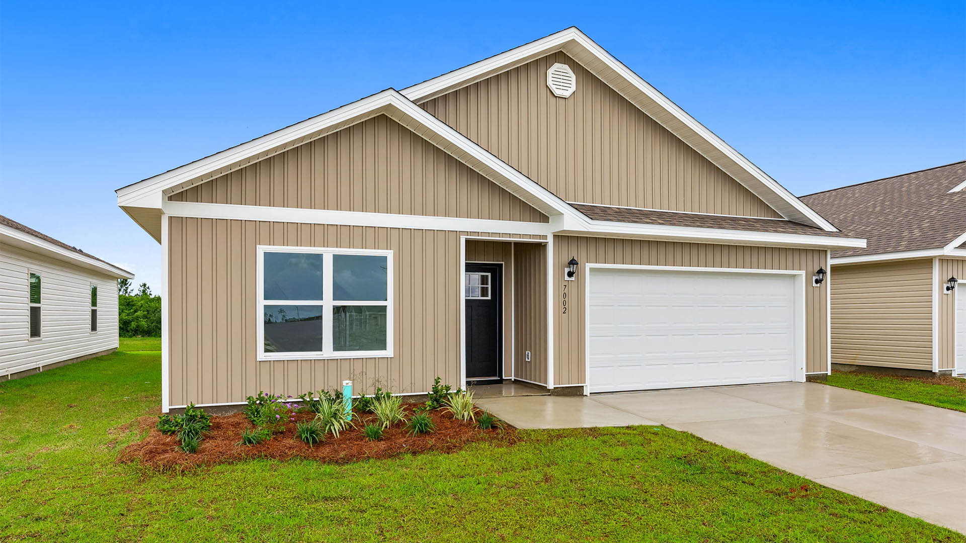 Beau plan with vinyl siding and two-car garage.