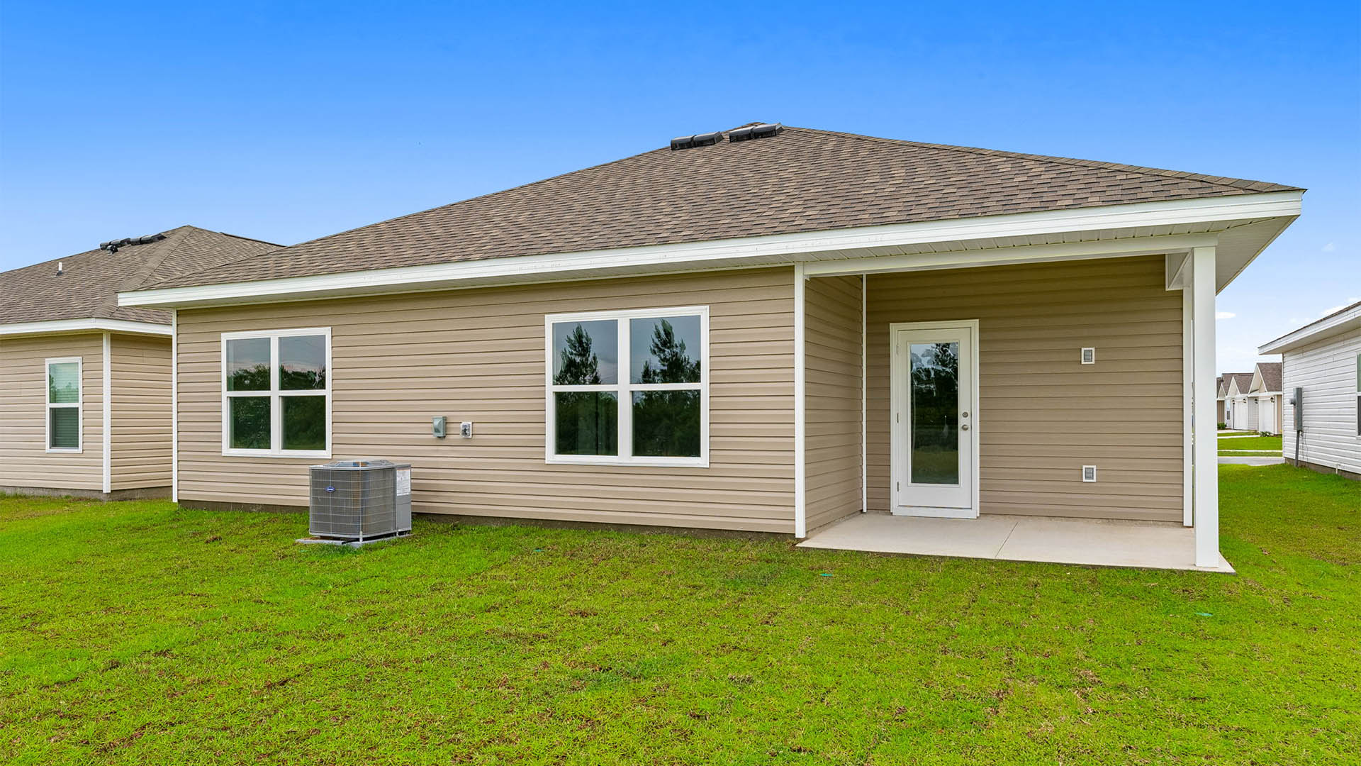 Beau plan rear of home with covered rear patio.