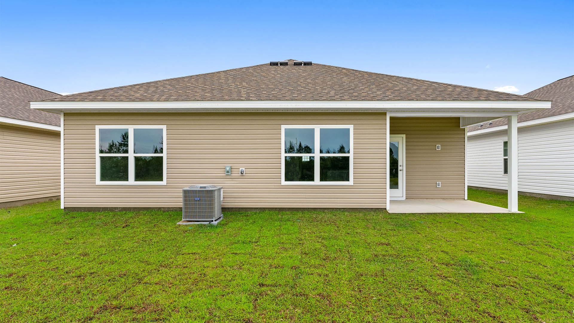 Beau plan rear of home with covered rear patio.