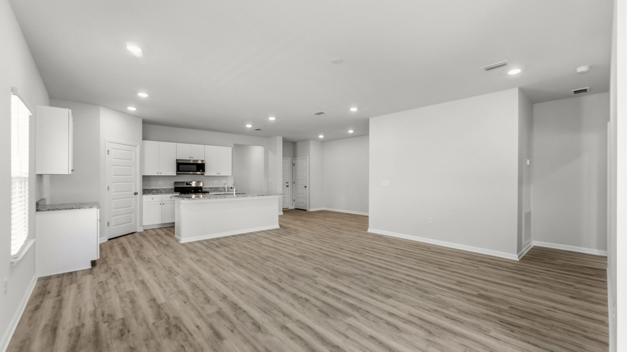 Living room and kitchen view with EVP flooring.