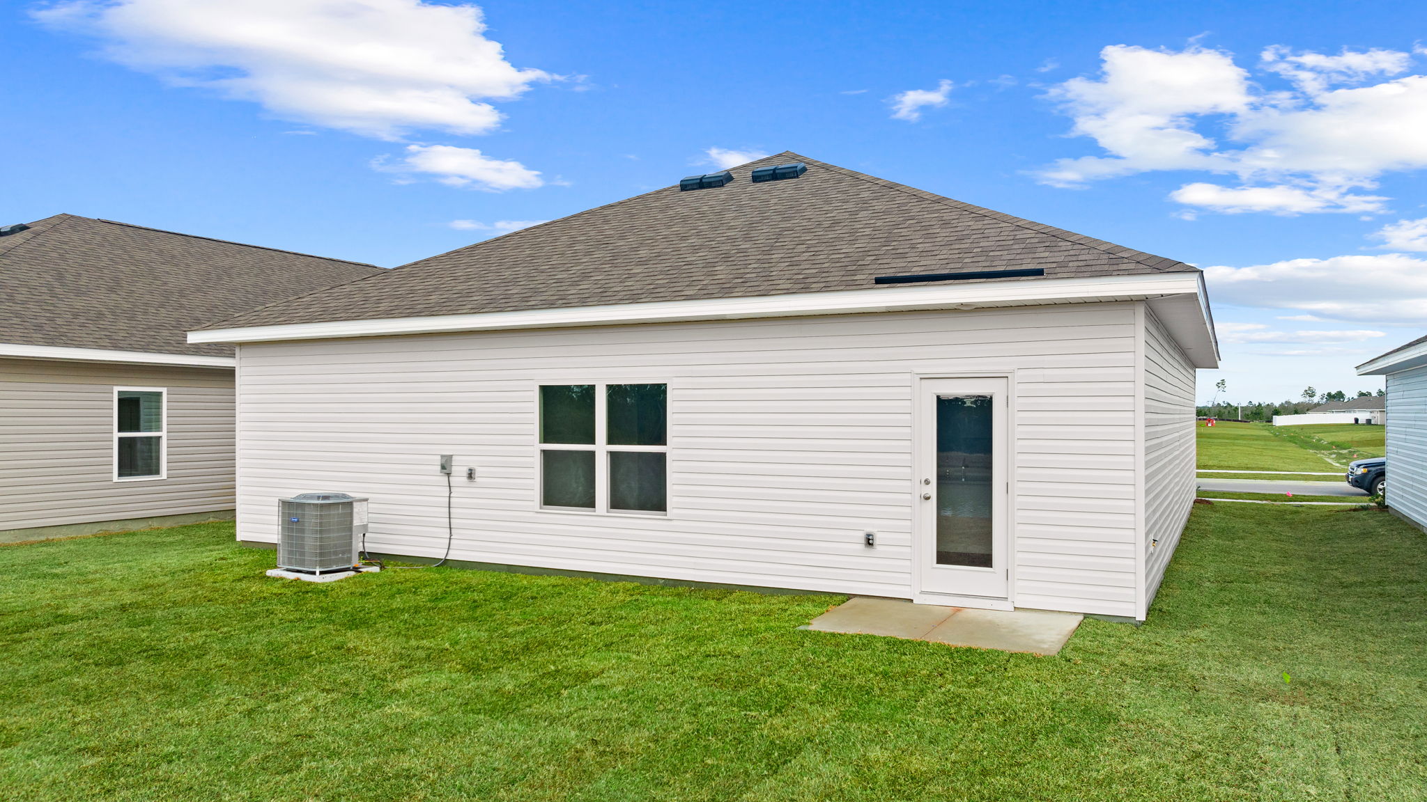 Eldridge plan rear of home with concrete pad and back yard.