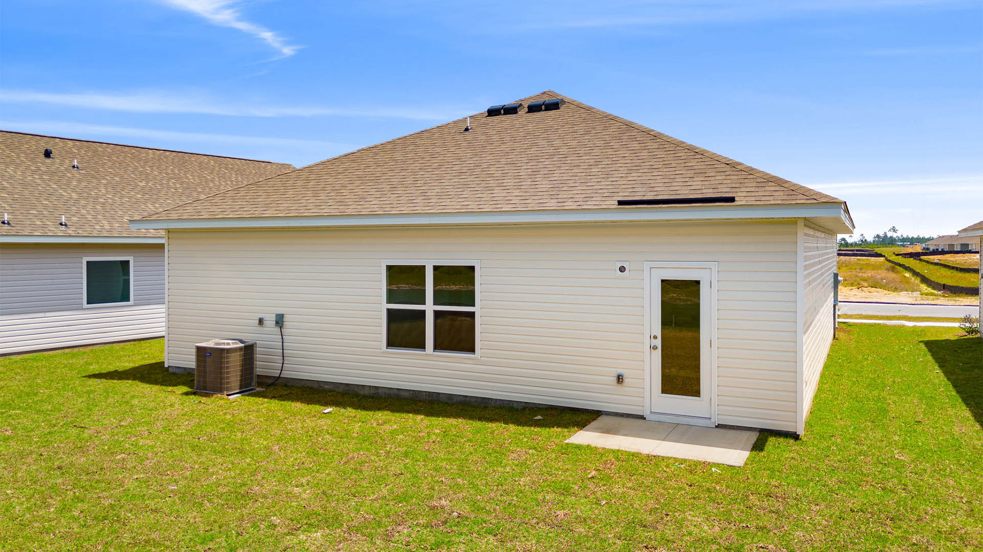 Eldridge plan rear of home with concrete pad and back yard.