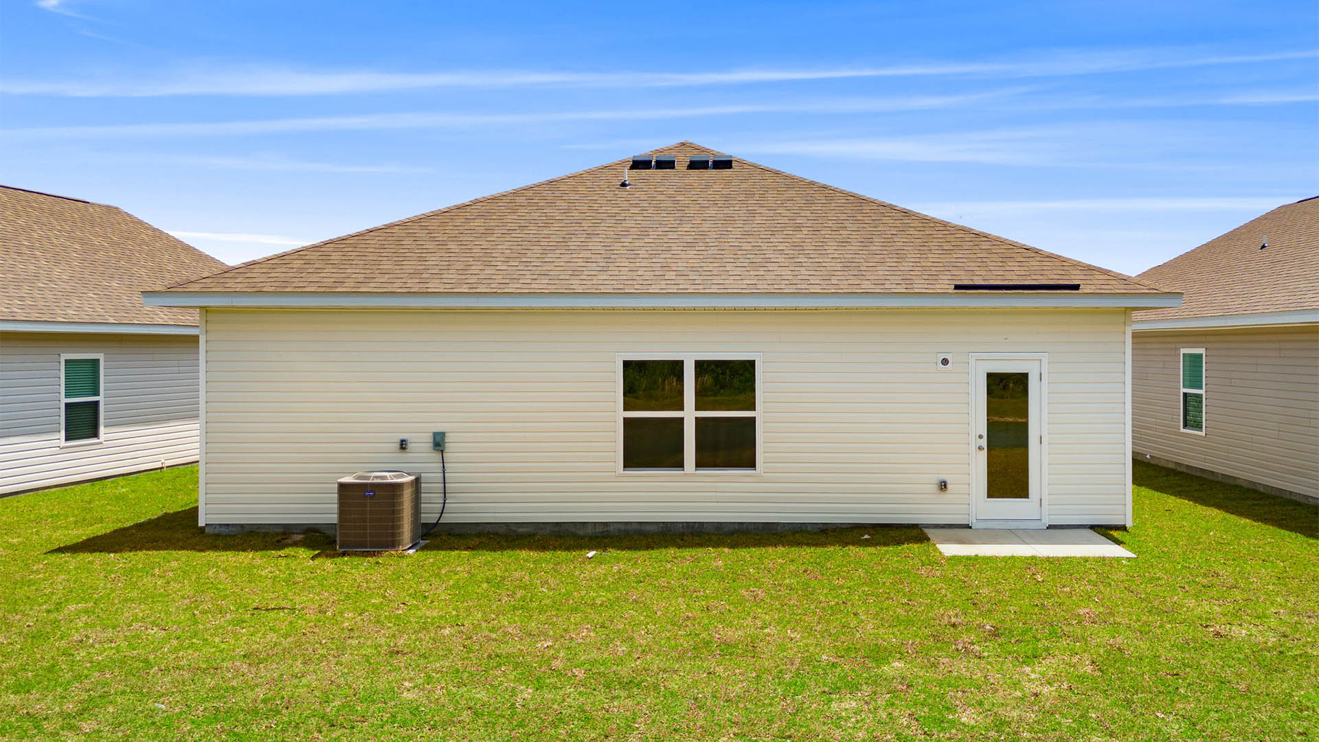 Eldridge plan rear of home with concrete pad and back yard.