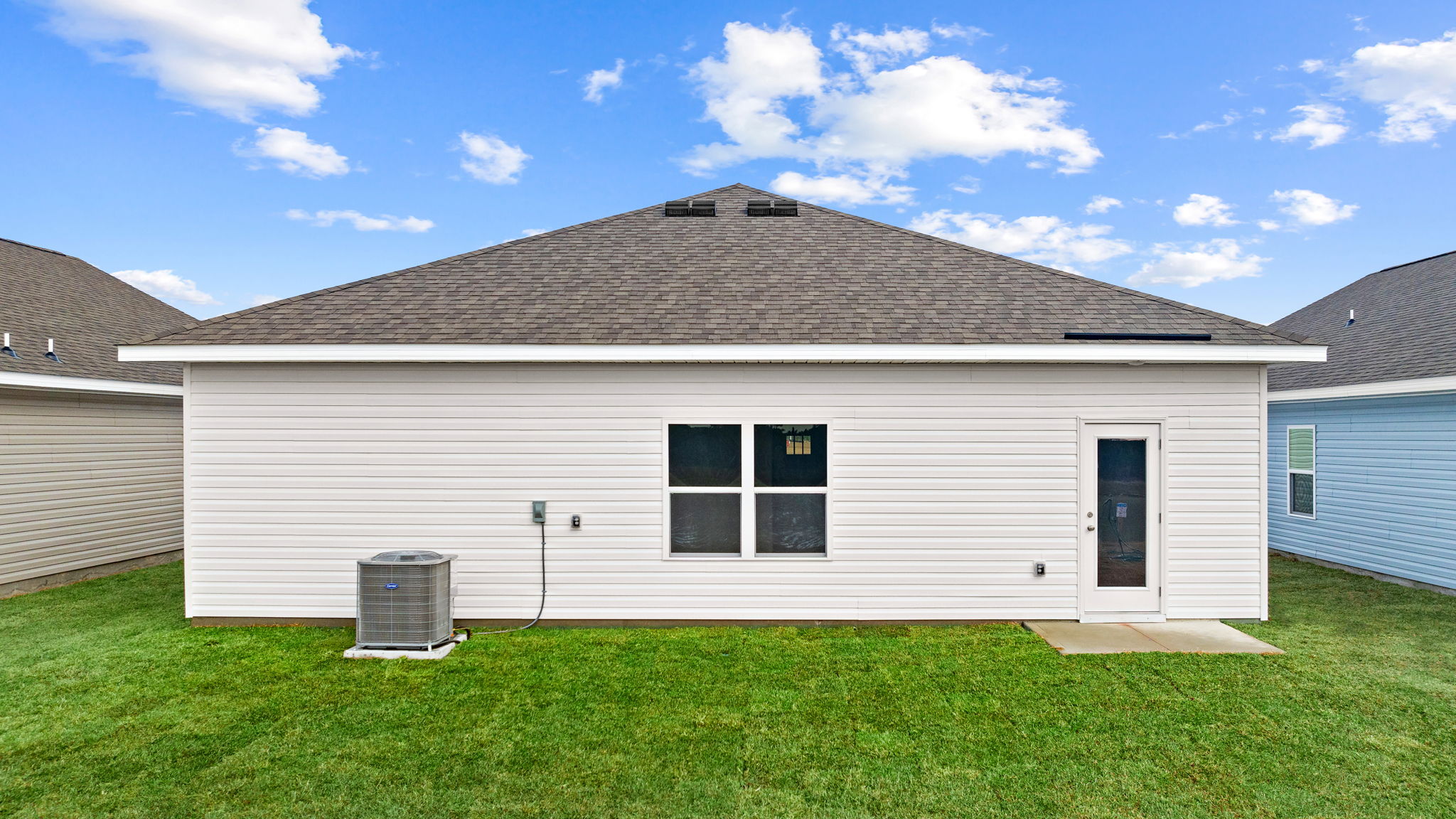 Eldridge plan rear of home with concrete pad and back yard.