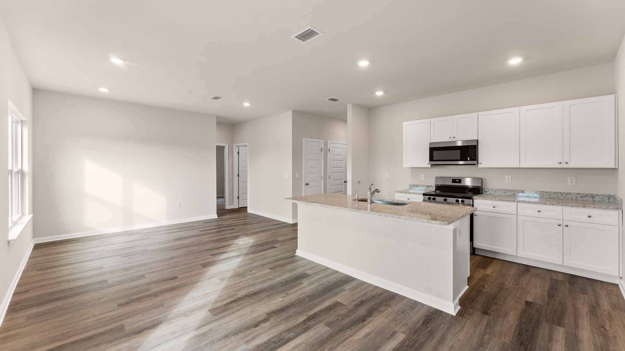 Living room and kitchen view next to back door.