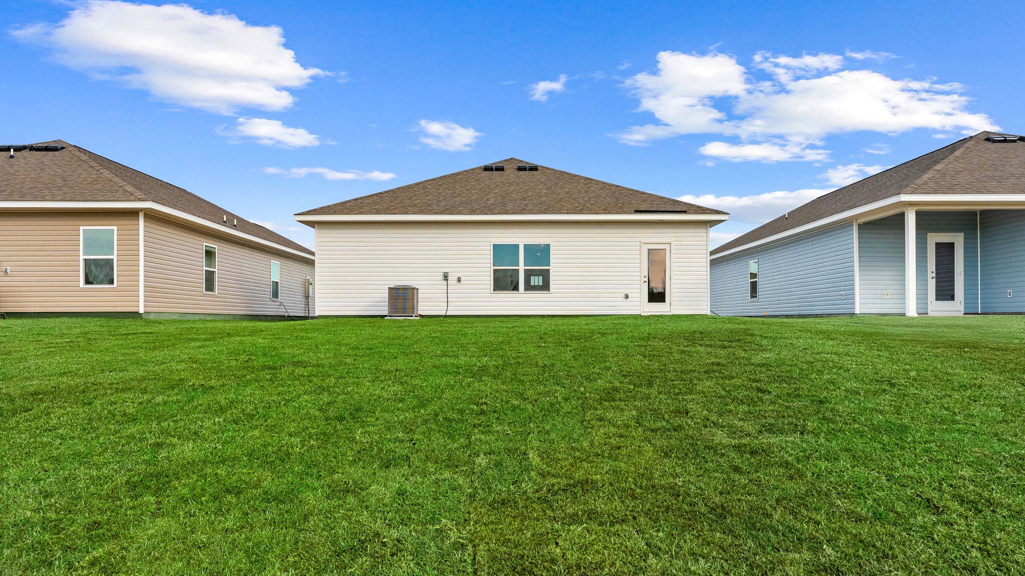 Eldridge plan rear of home with concrete pad and back yard.