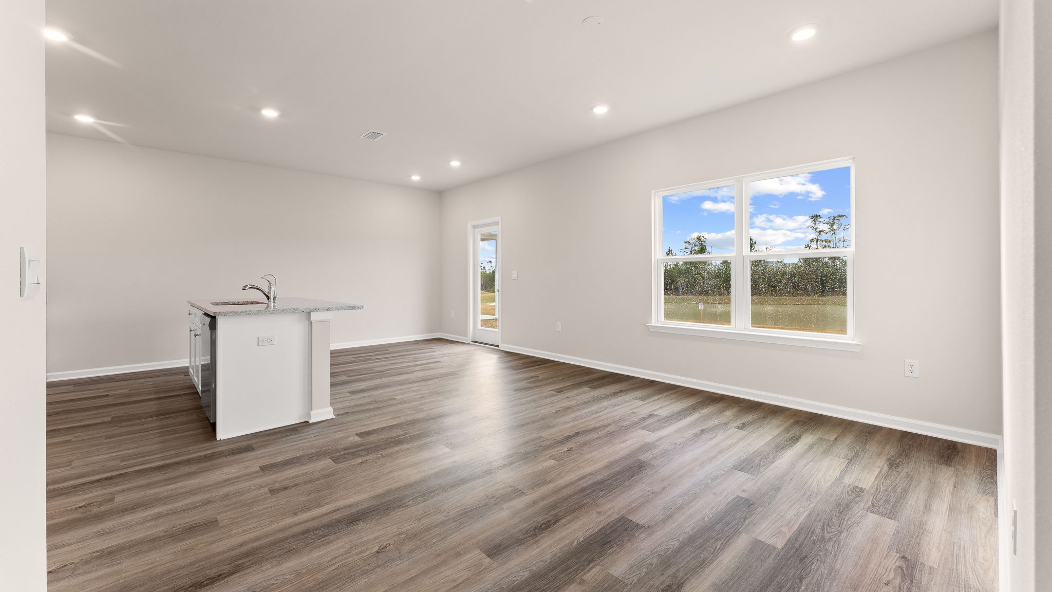 Living room with EVP flooring and kitchen and dining area.