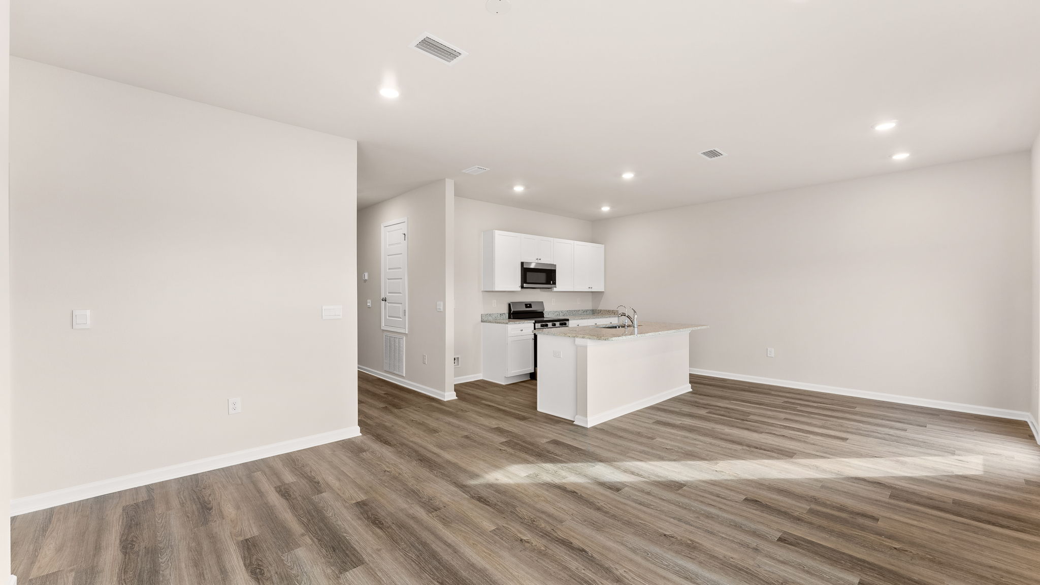 Living room and kitchen view next to bedrooms.