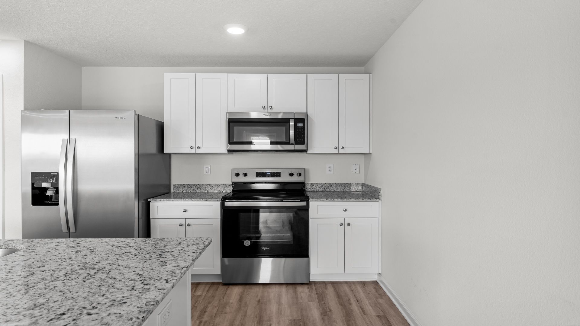 Kitchen island with granite countertops and stainless-steel appliances and pantry.
