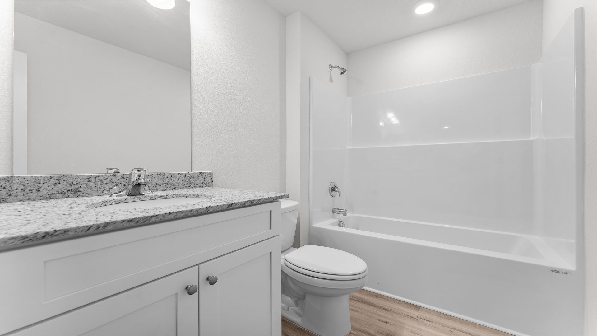 Bathroom with granite countertops and single vanity and shower and tub.