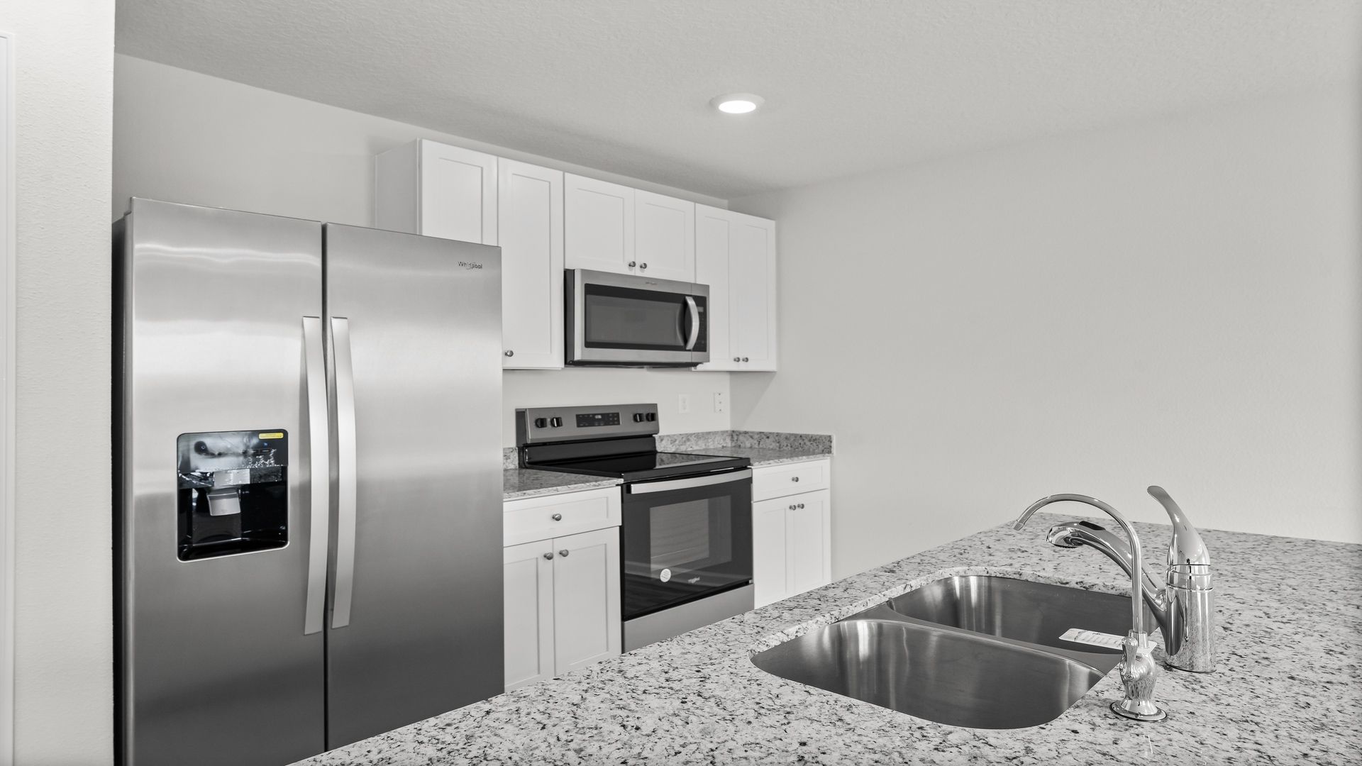 Kitchen island with granite countertops and stainless-steel appliances and pantry.