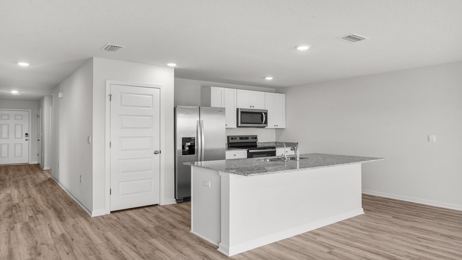 Kitchen island with granite countertops and stainless-steel appliances and pantry.
