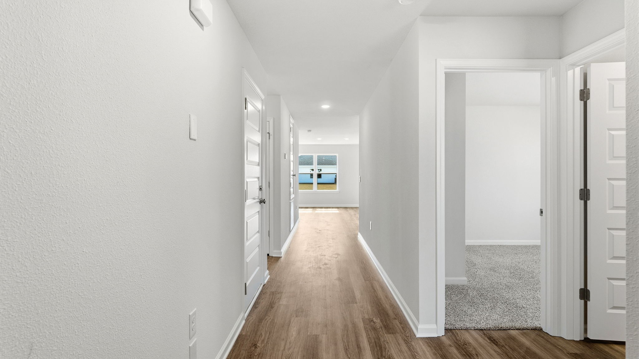 Front entrance next to bedroom with front door and EVP flooring.
