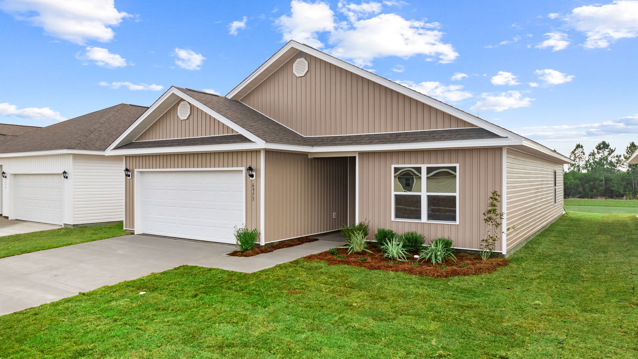 Walker plan at Liberty front of home with vinyl siding and two car garage.