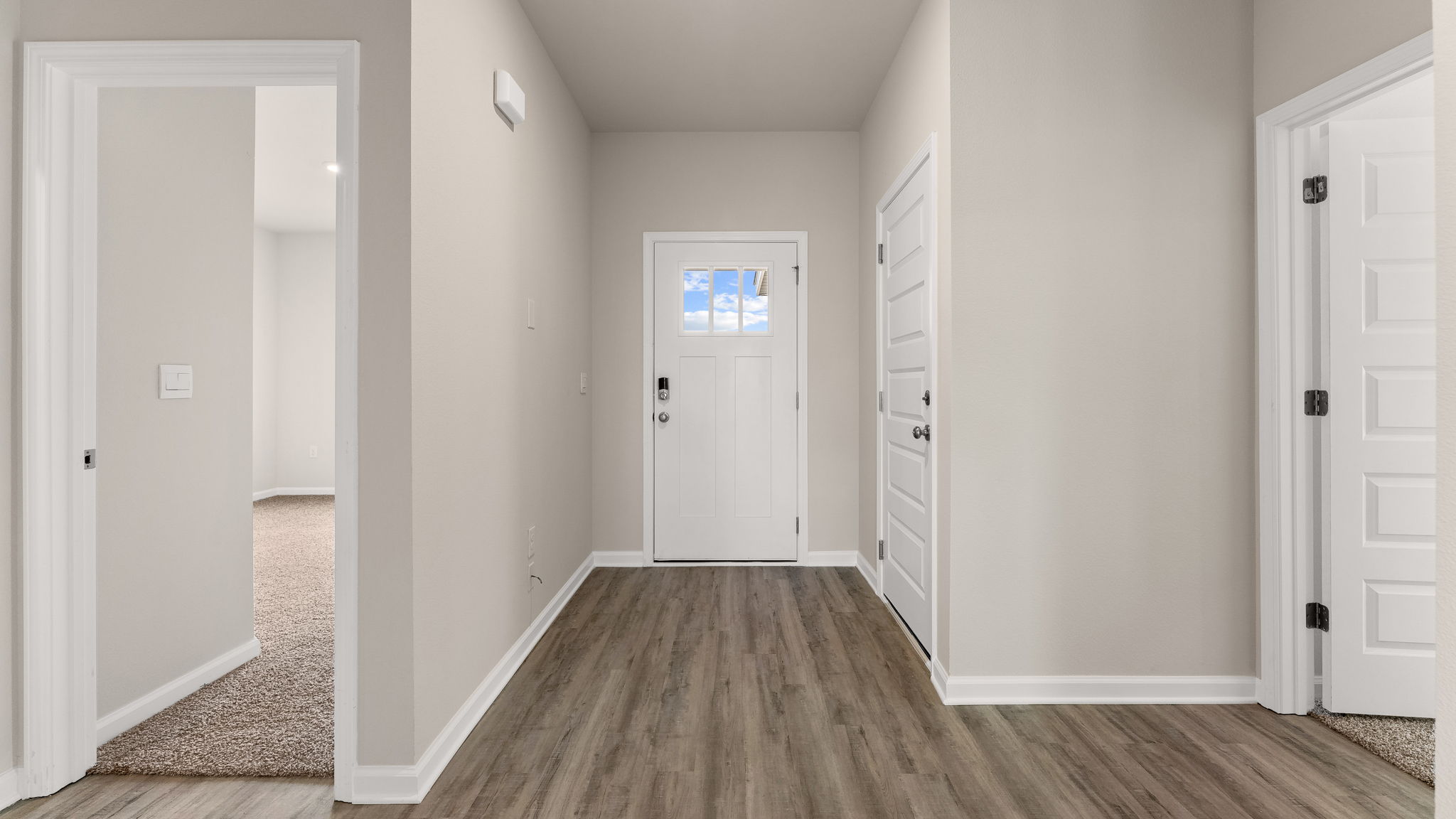 Front entrance hallway with EVP flooring next to garage and bedrooms.