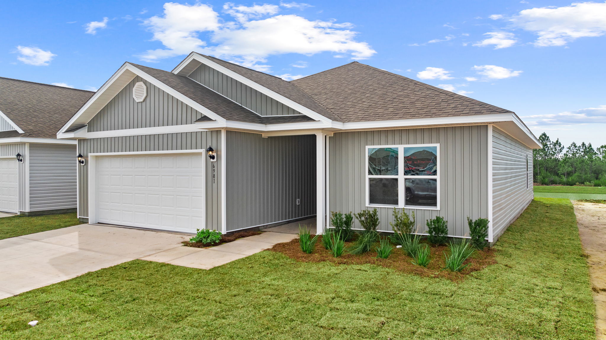 Walker plan at Liberty front of home with vinyl siding and two car garage.