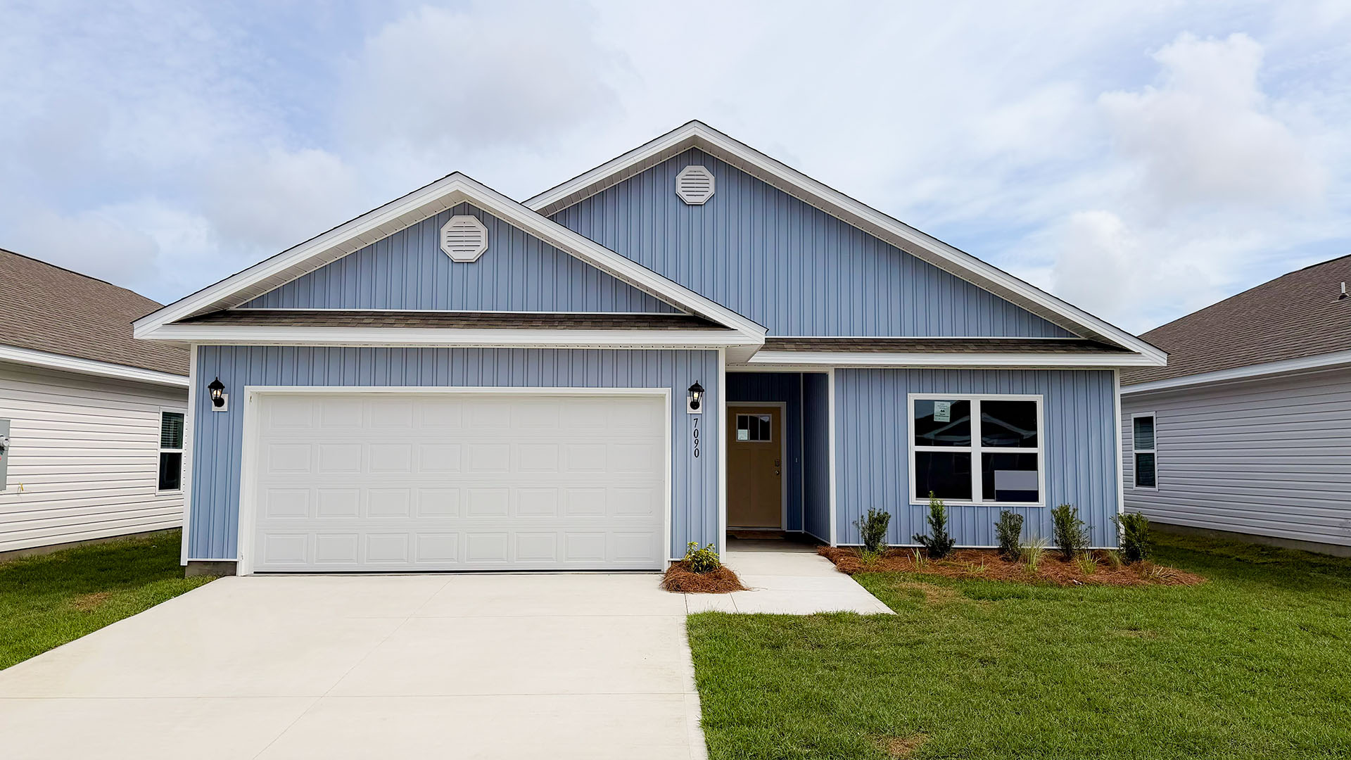 Walker plan at Liberty front of home with vinyl siding and two car garage.