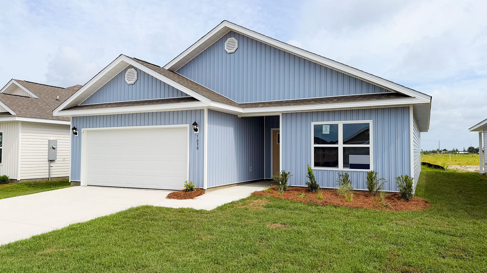 Walker plan at Liberty front of home with vinyl siding and two car garage.