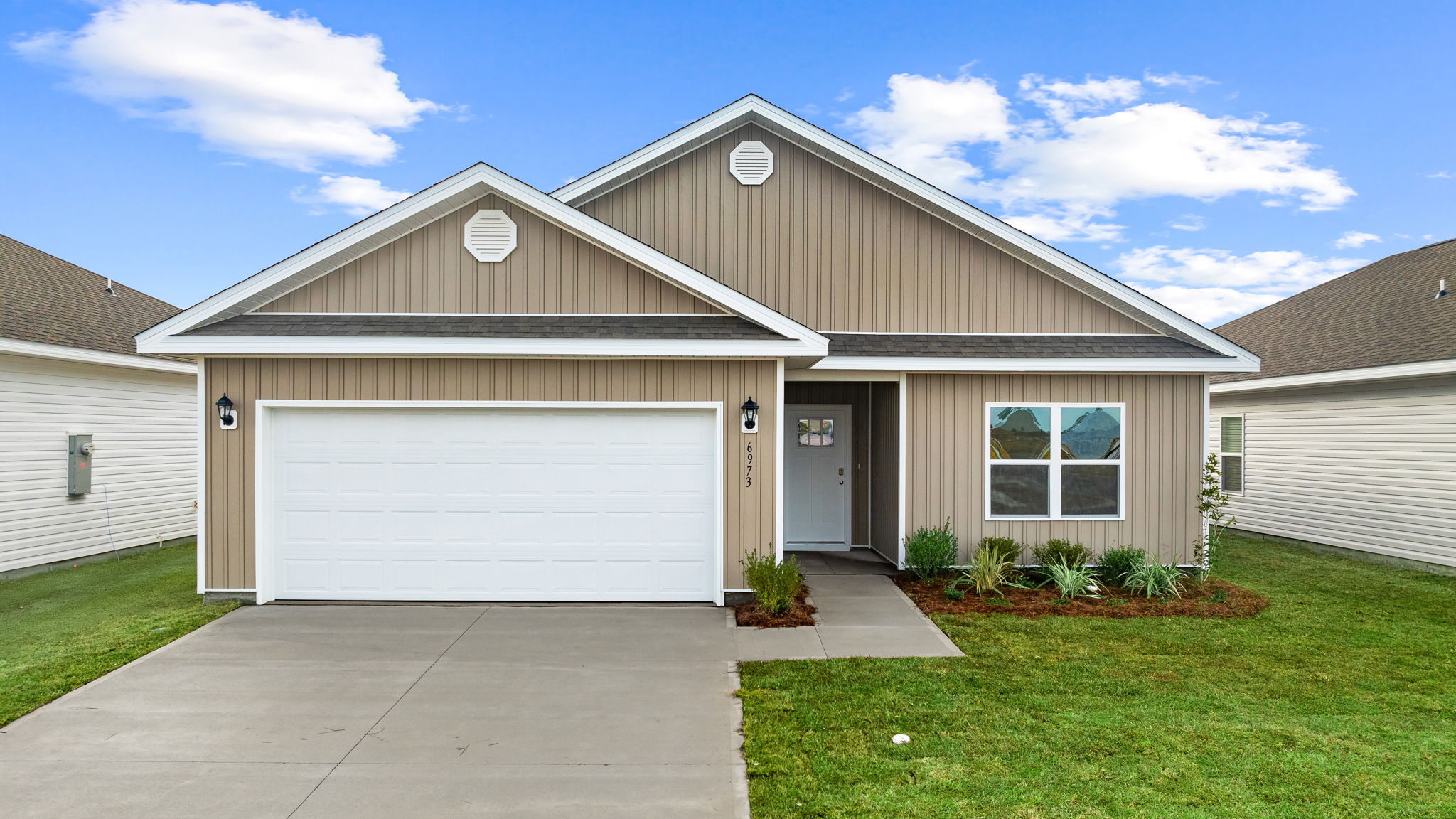 Walker plan at Liberty front of home with vinyl siding and two car garage.