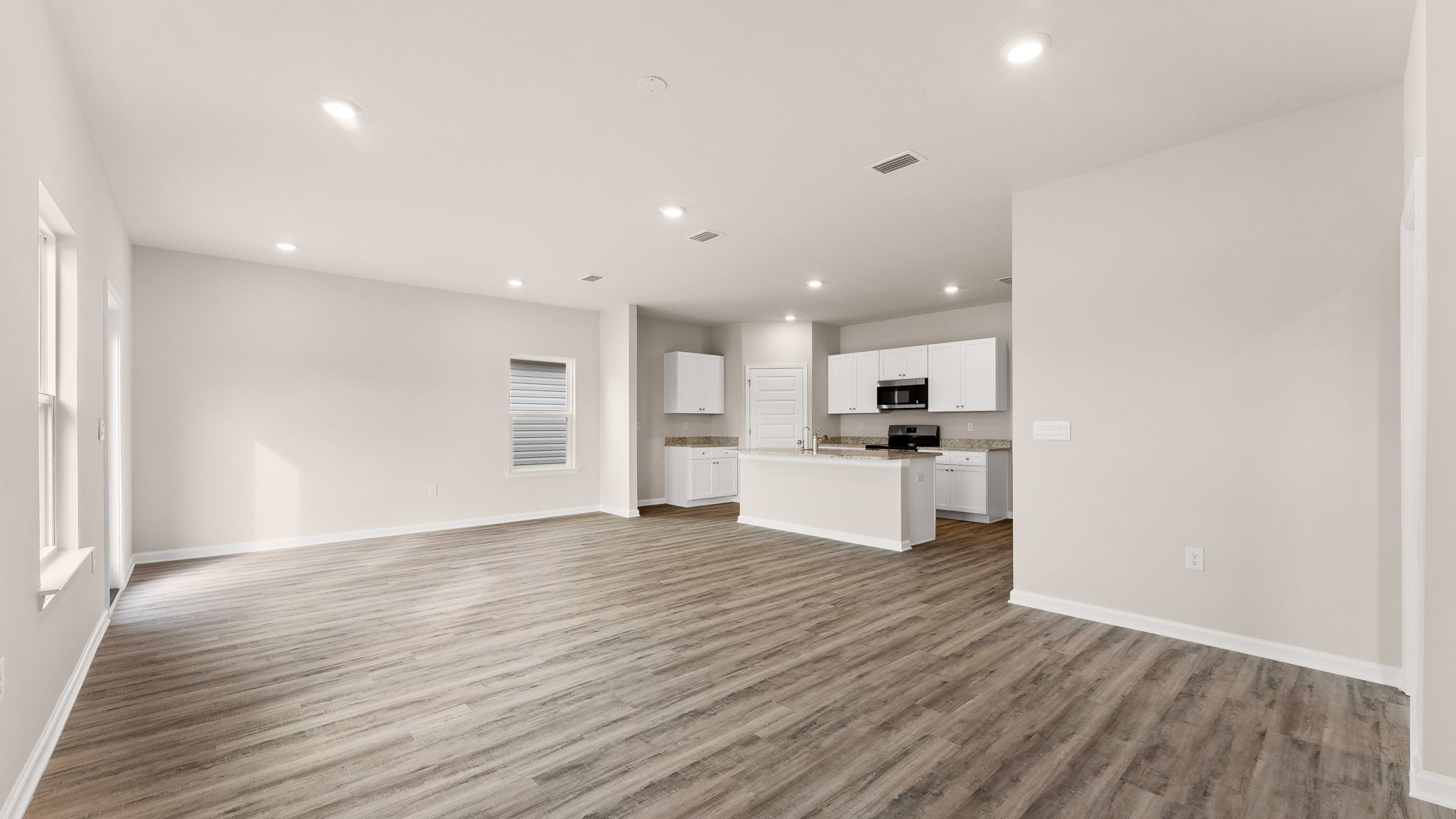 Living room and kitchen view next to primary bedroom.