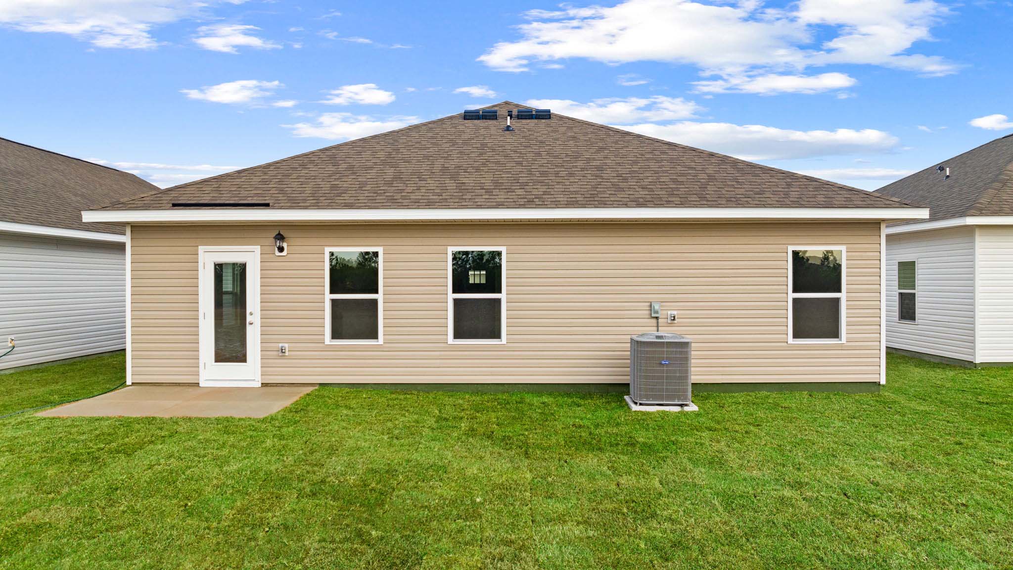 Walker plan rear of home with concrete pad and back yard.
