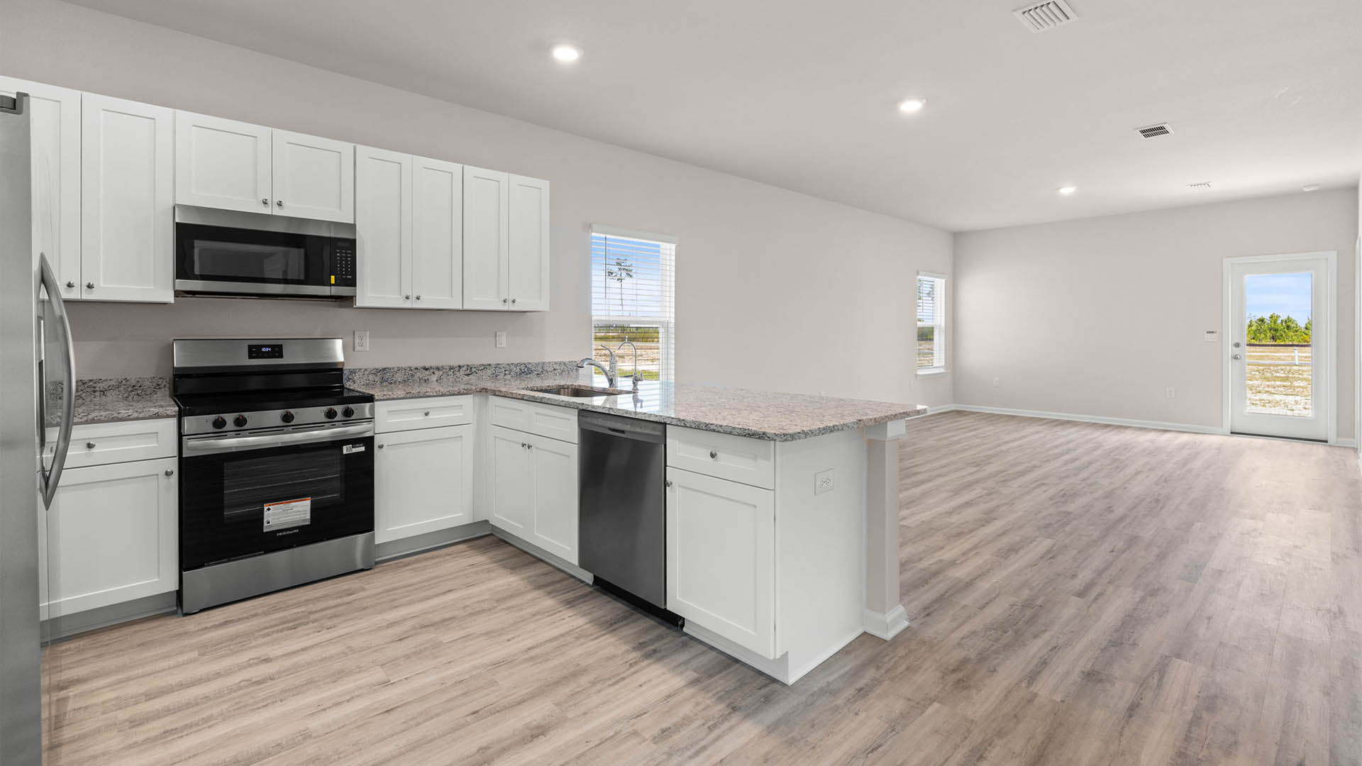 Kitchen with granite countertops and stainless-steel appliances and pantry.