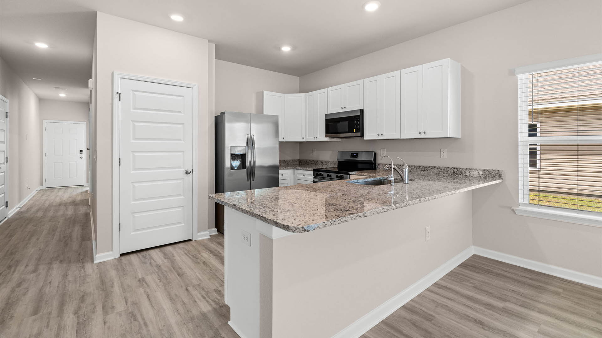 Kitchen with granite countertops and stainless-steel appliances and pantry.