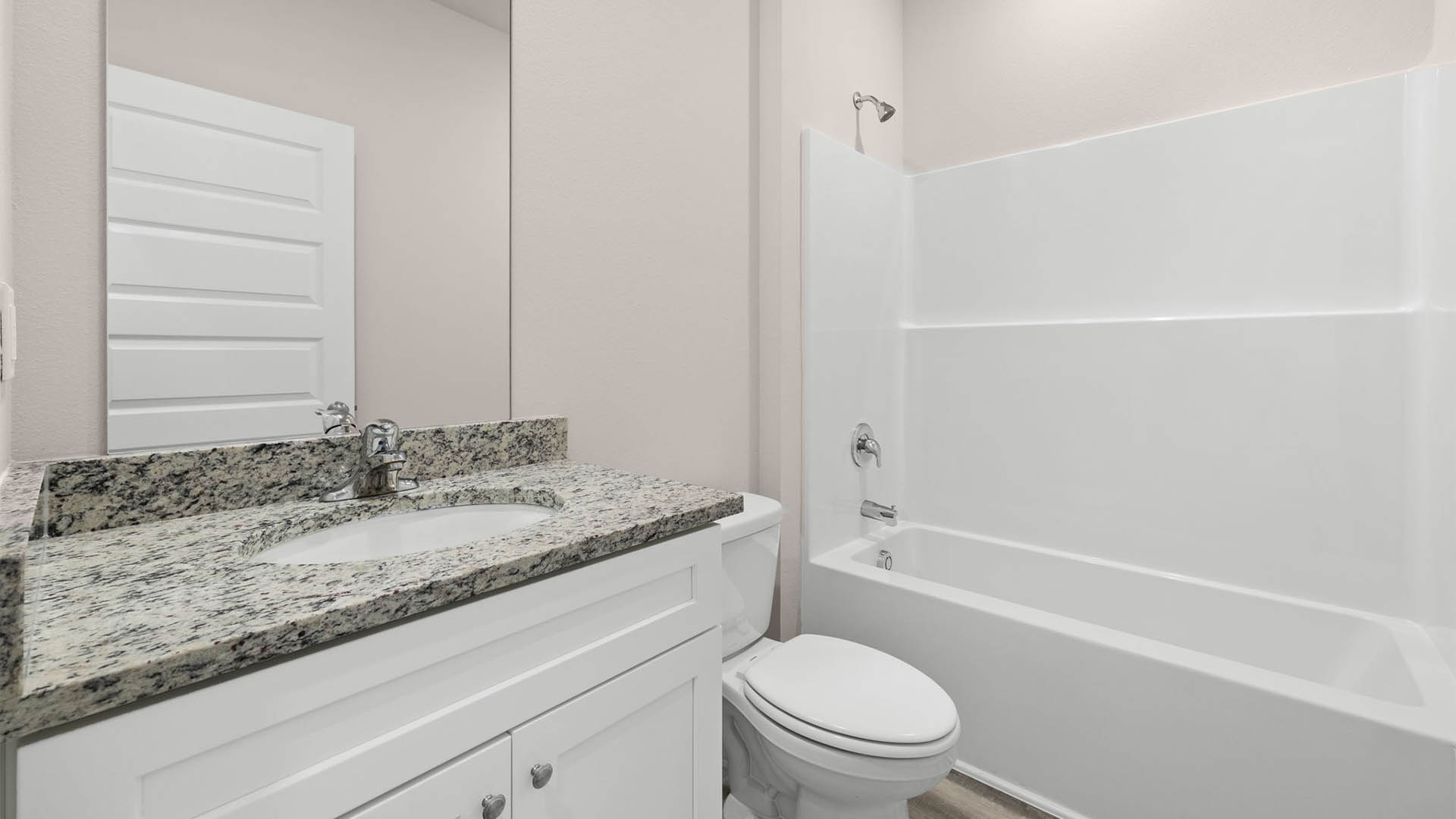 Bathroom with granite countertops and single vanity and toilet and shower.