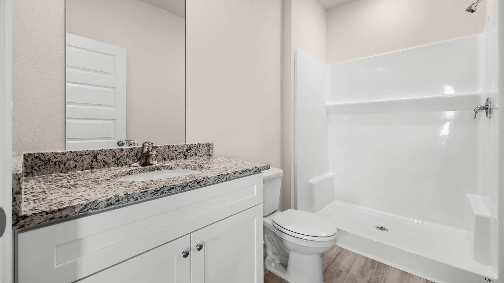Bathroom with granite countertops and single vanity and toilet and shower.