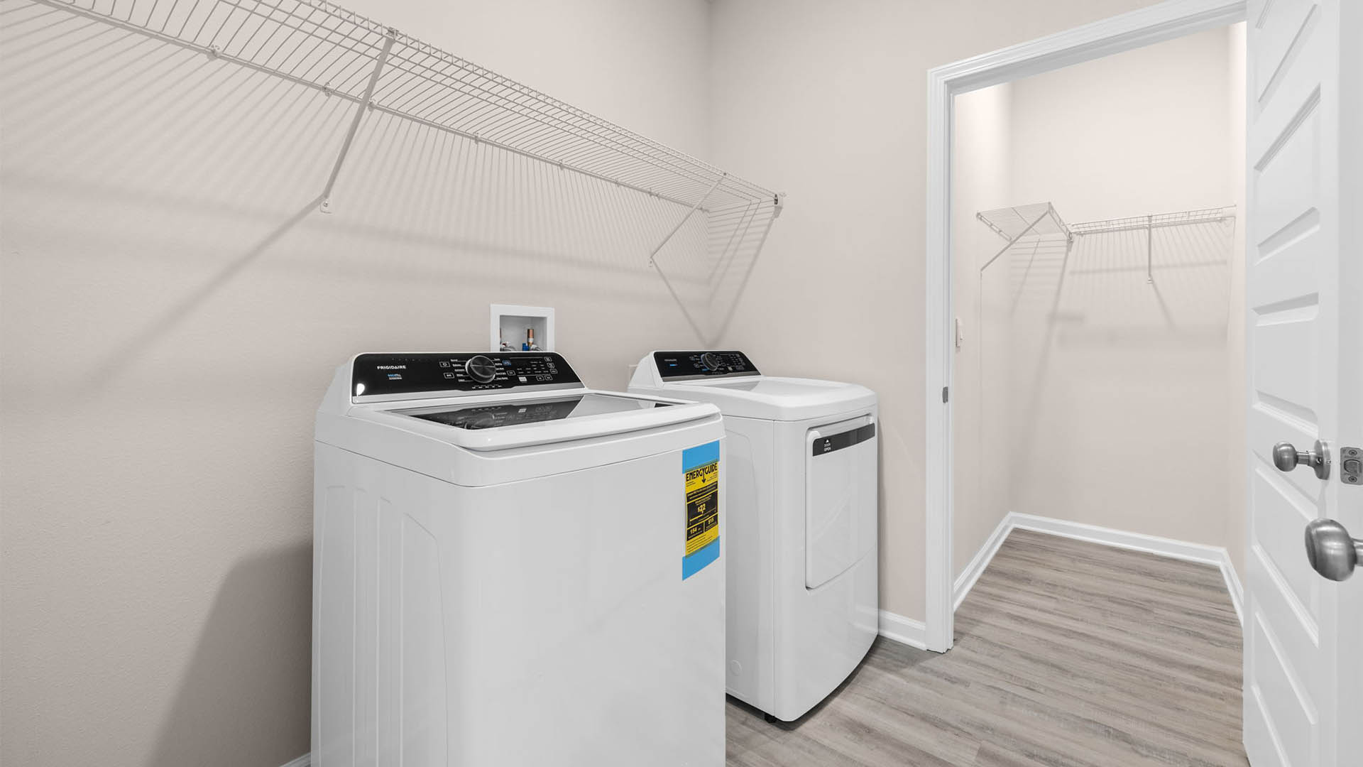 Laundry room with shelving and EVP floors and closet.