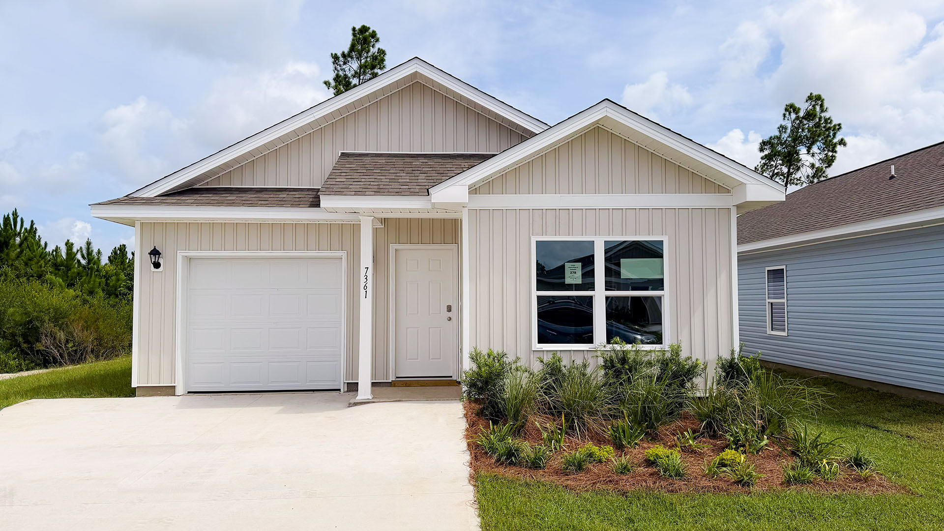 Poppy plan with vinyl siding and single car garage.