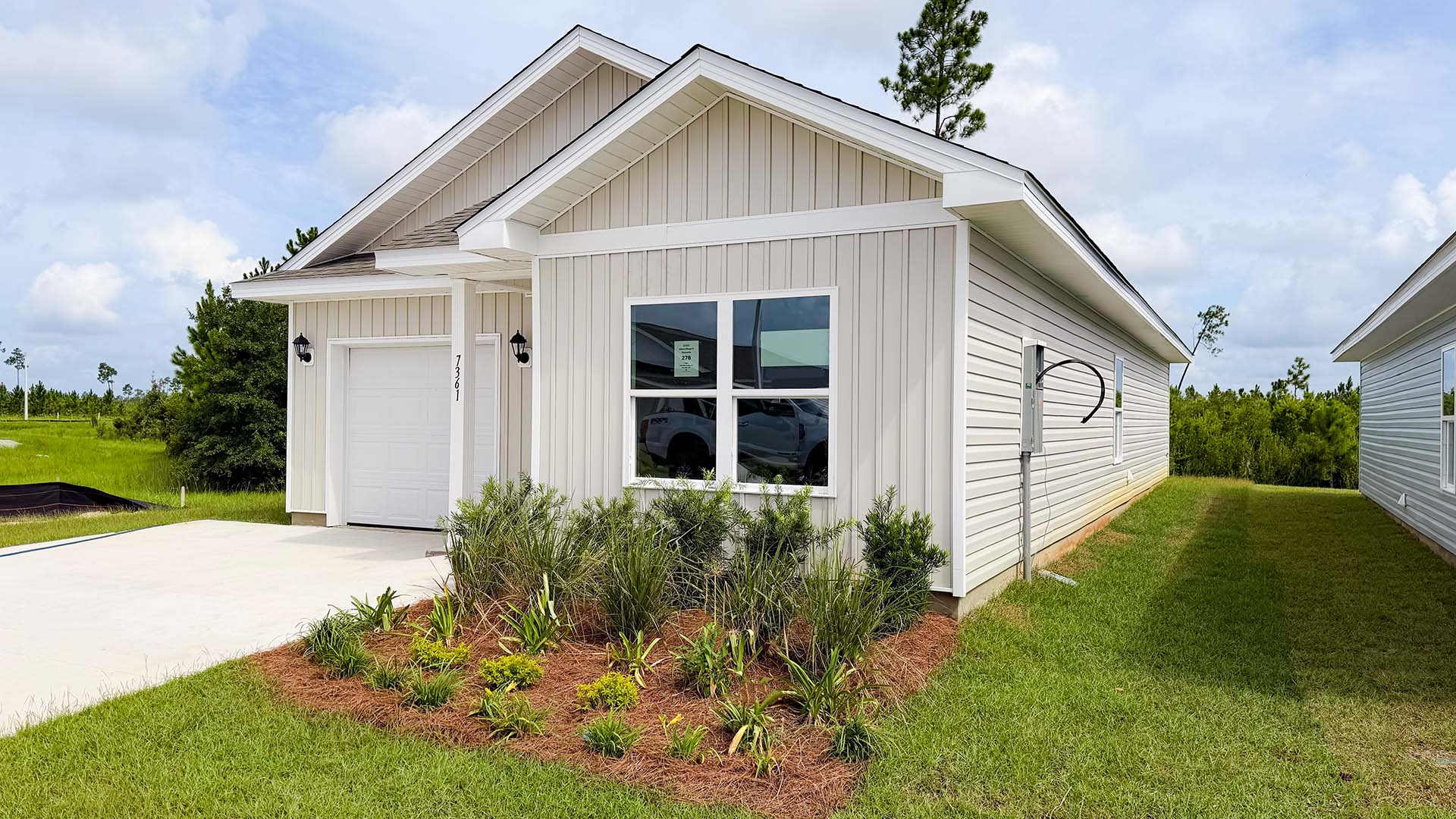 Poppy plan with vinyl siding and single car garage.