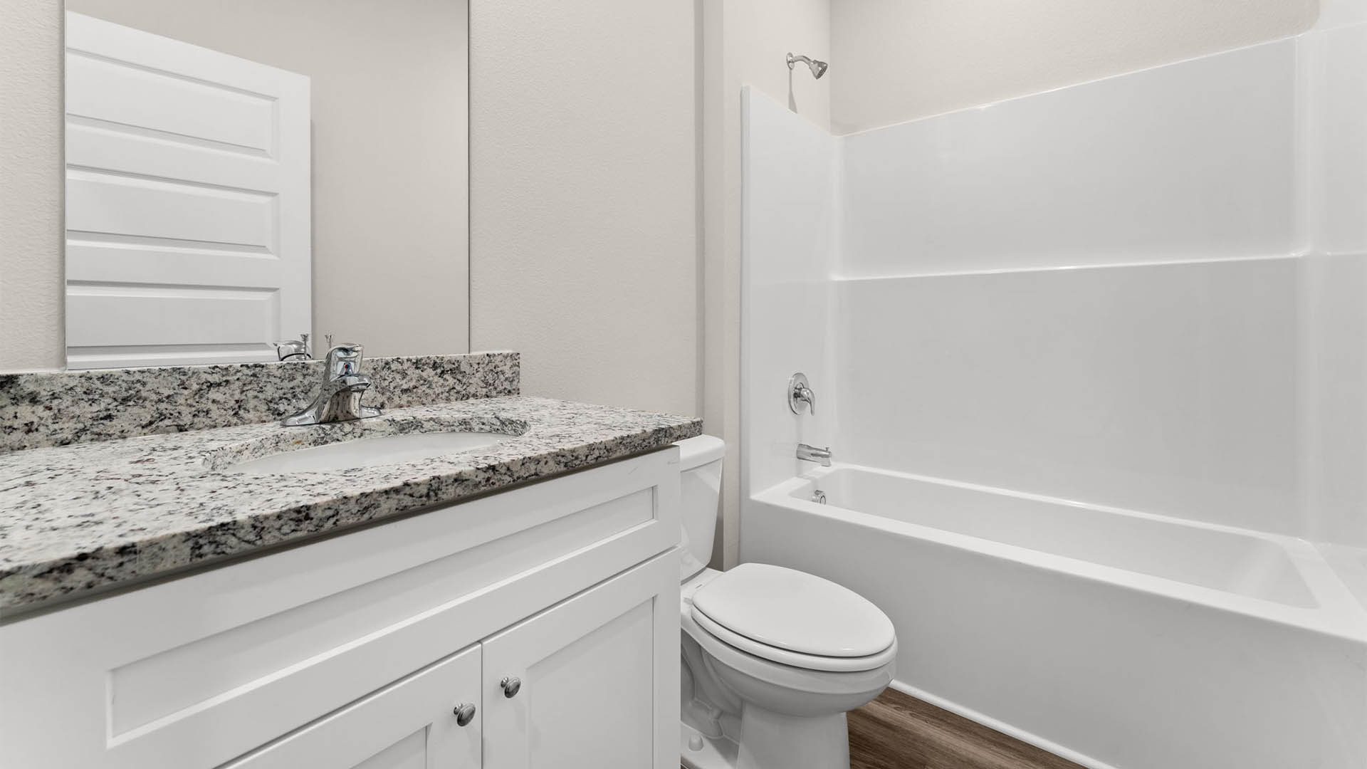 Bathroom with granite countertops and single vanity and toilet and shower.