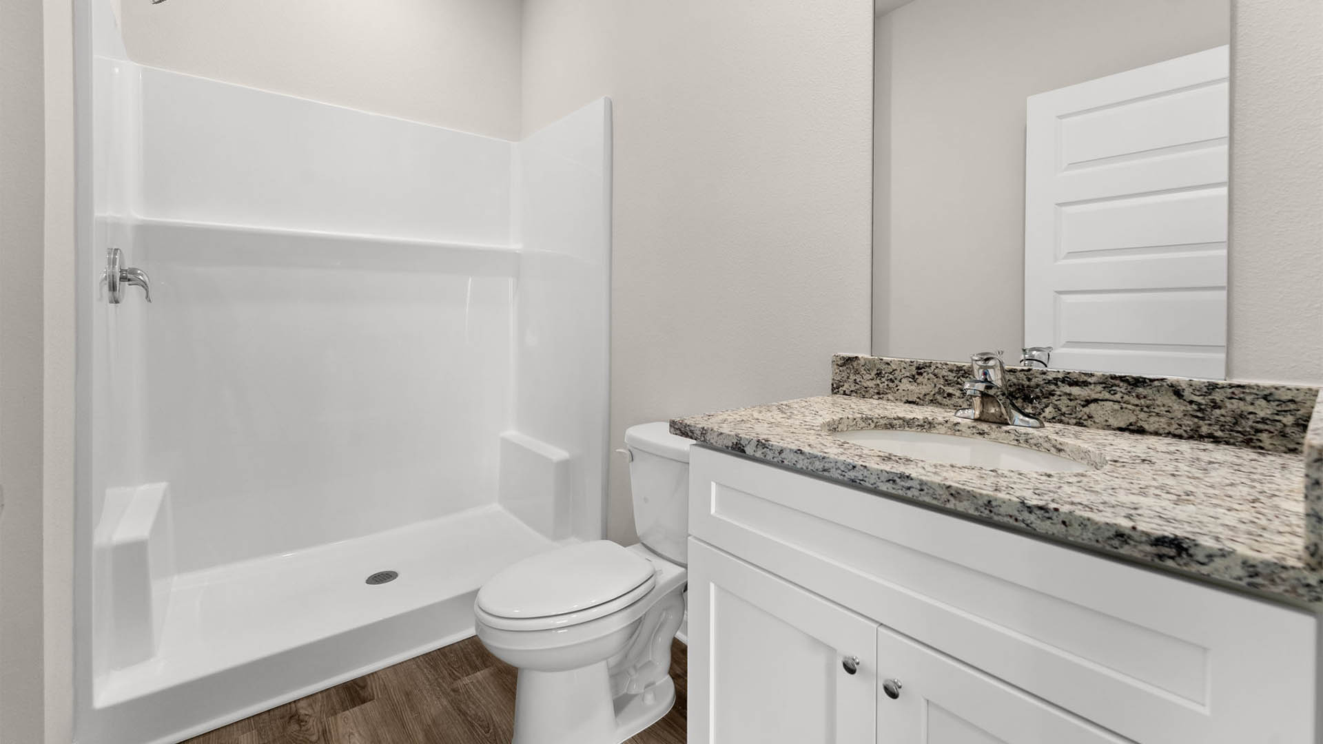 Bathroom with granite countertops and single vanity and toilet and shower.
