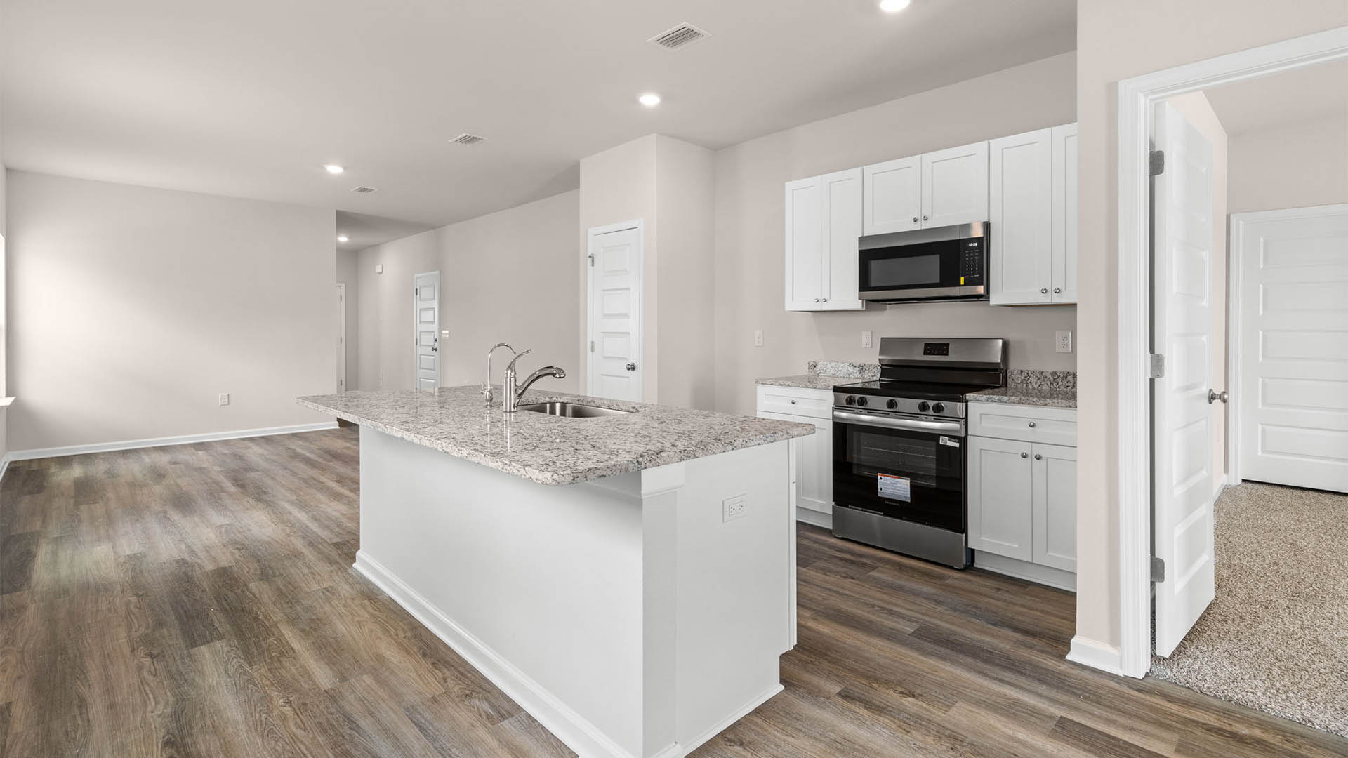 Kitchen with granite countertops and stainless-steel appliances and pantry.