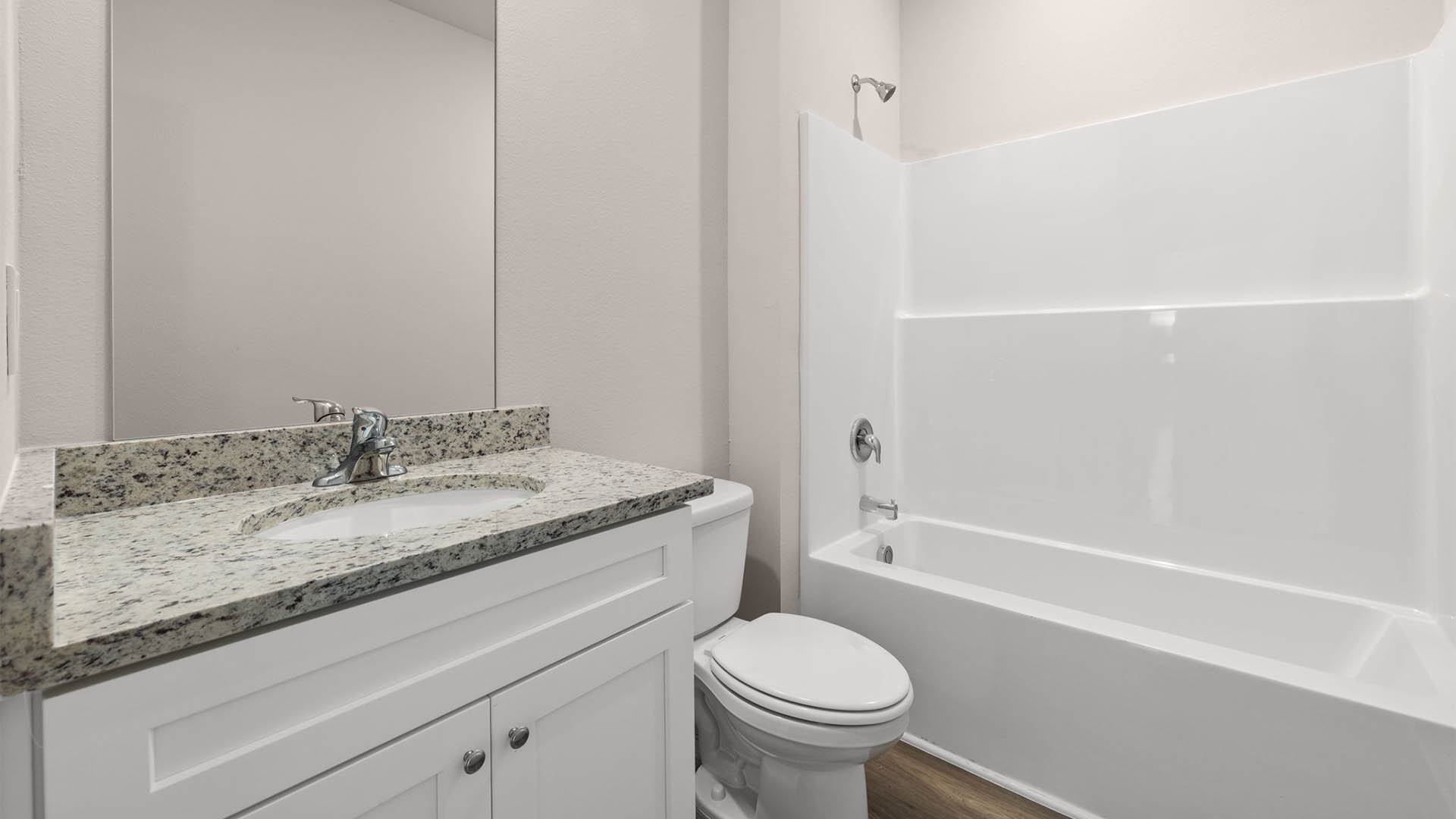 Bathroom with granite countertops and single vanity and toilet and shower.