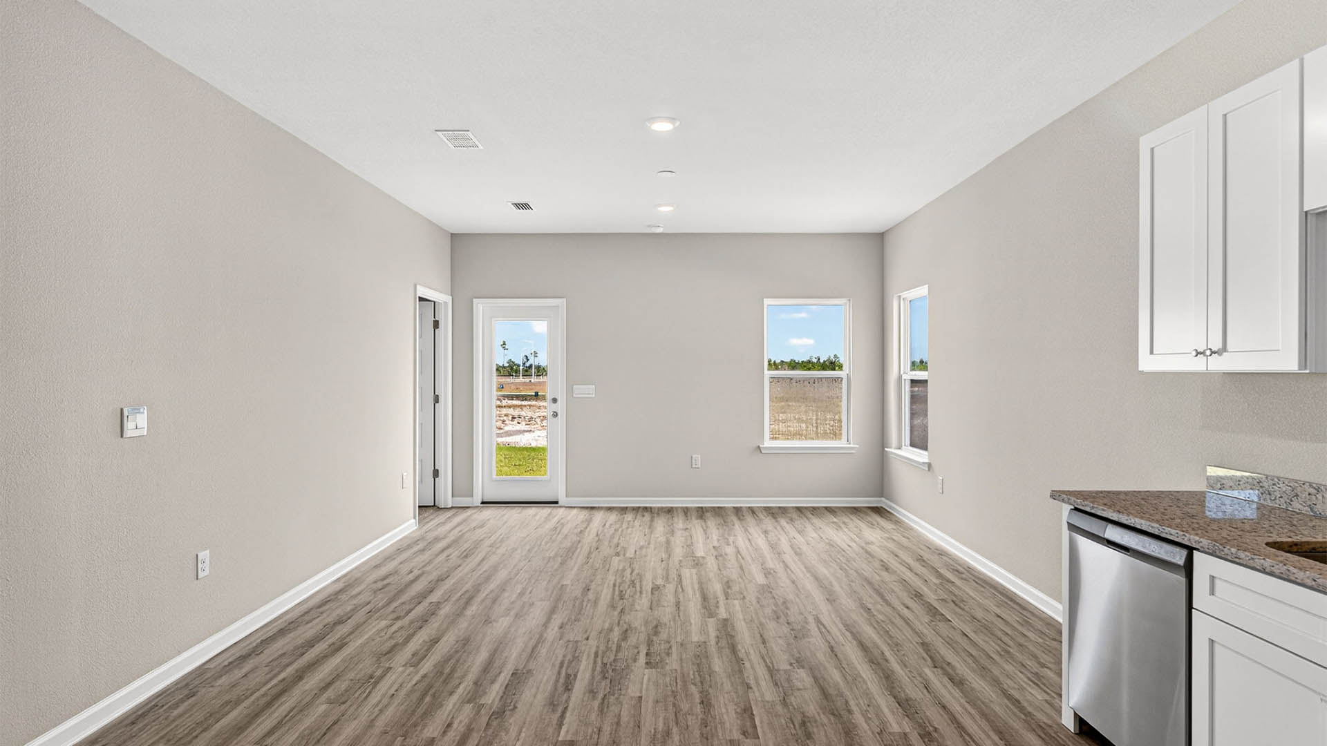 Open living room and kitchen with EVP flooring and back door.