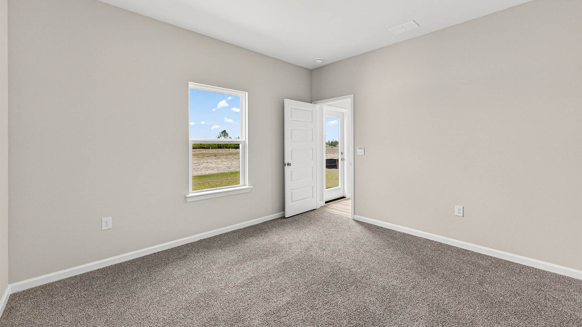 Primary bedroom with carpet floor and window and entrance.