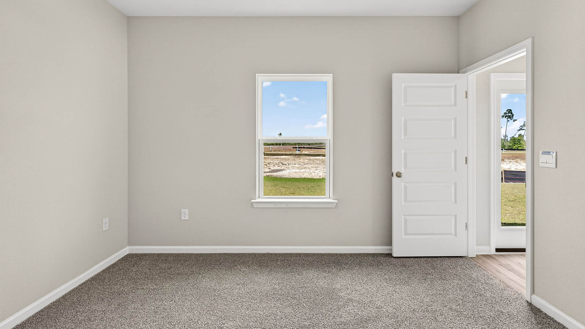 Primary bedroom with carpet floor and window and entrance.